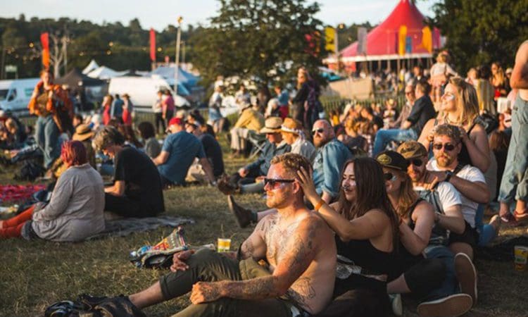 Crowds of people sat down in lines at a festival