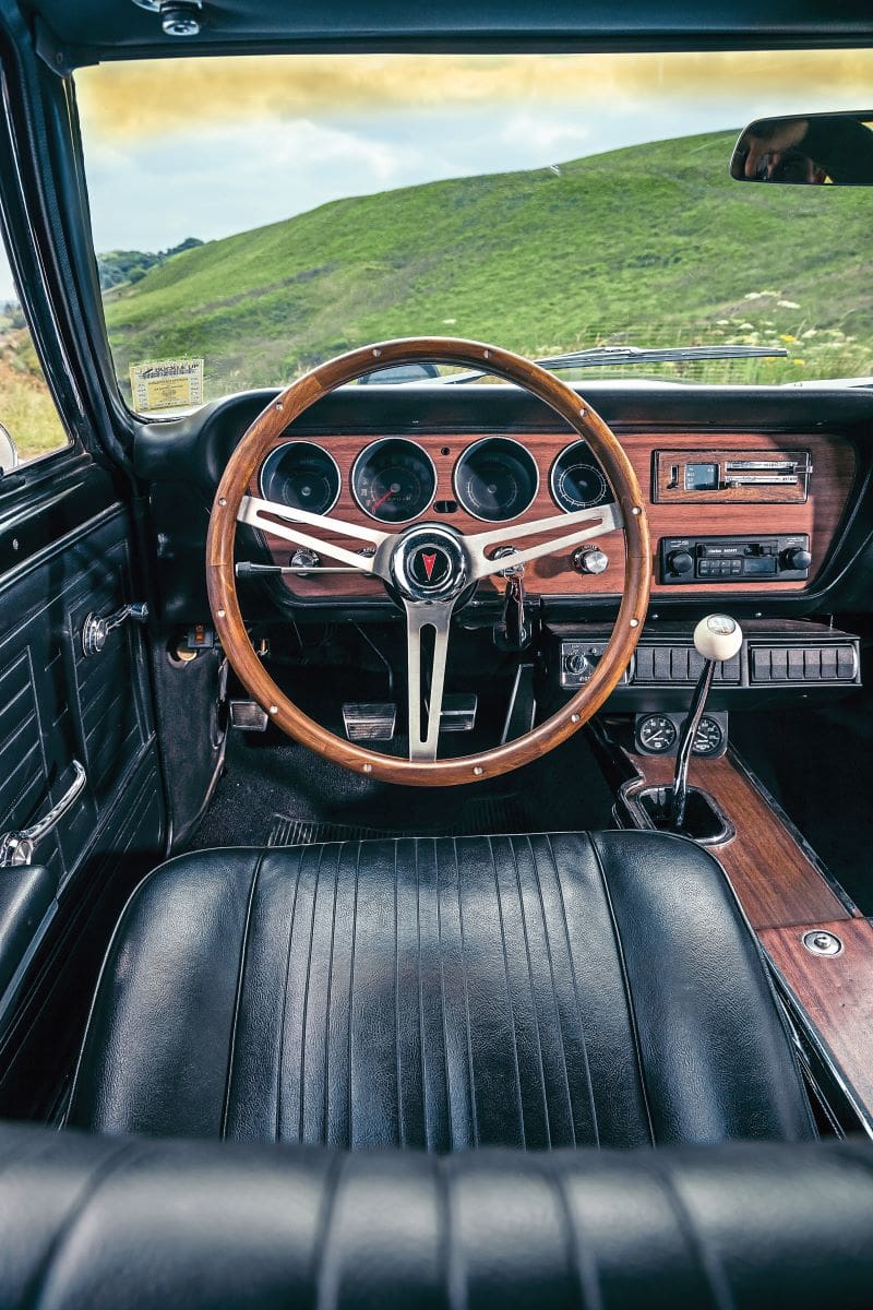 Black leather drivers seat and the wood rim steering wheel