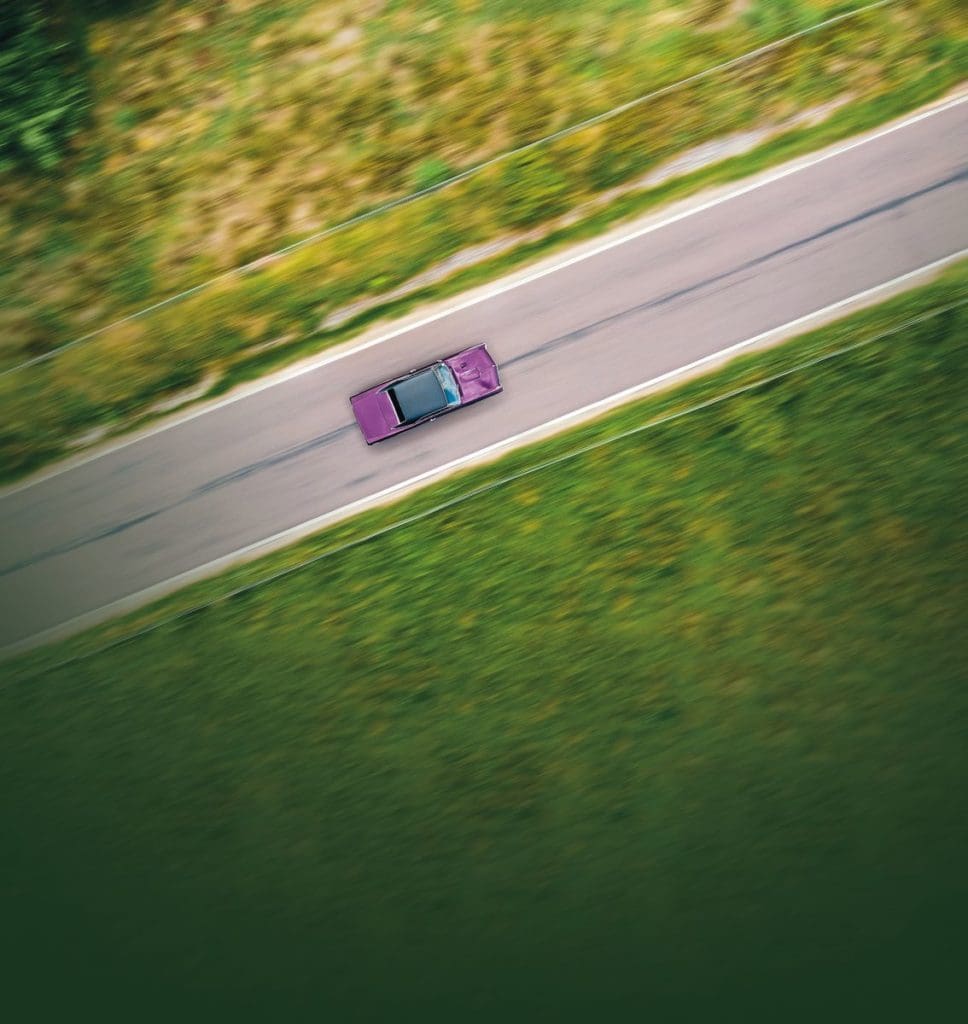 Aerial shot of the purple 1967 Pontiac GTO driving along a countryside road
