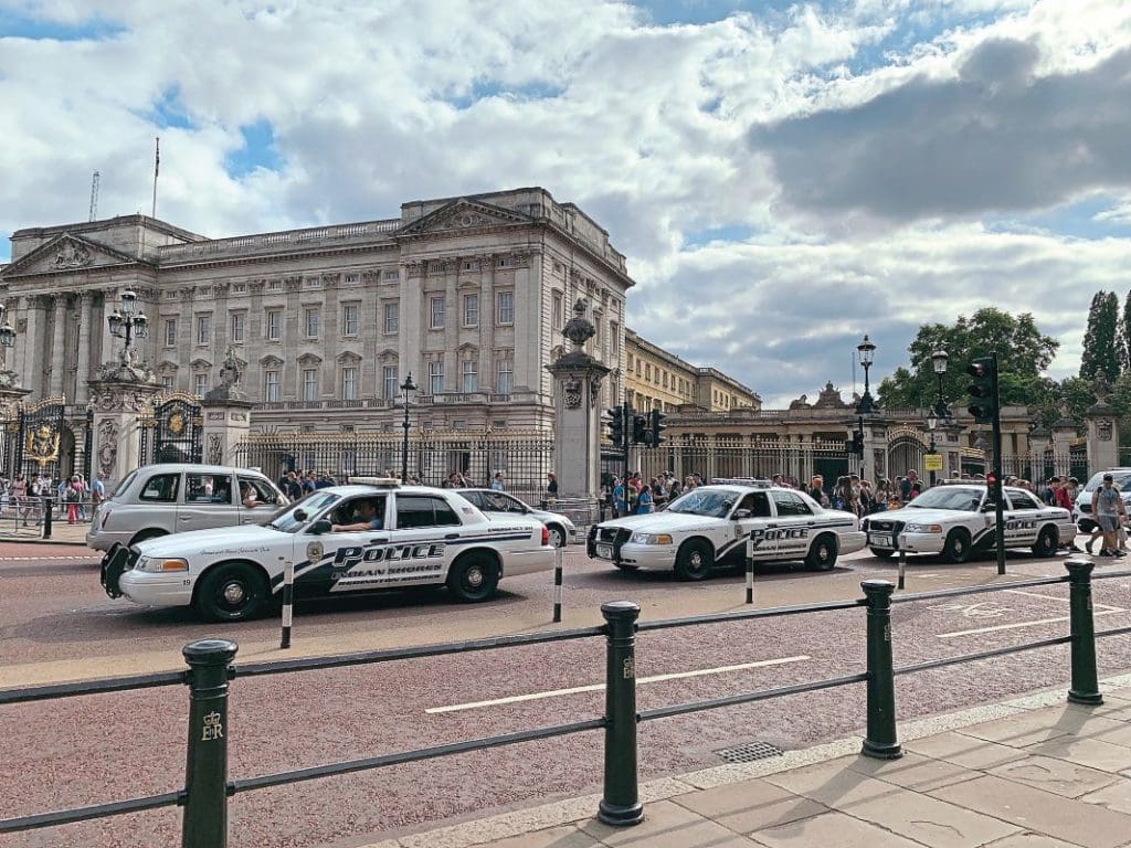 Three American police cars parked in front of Buckingham Palace