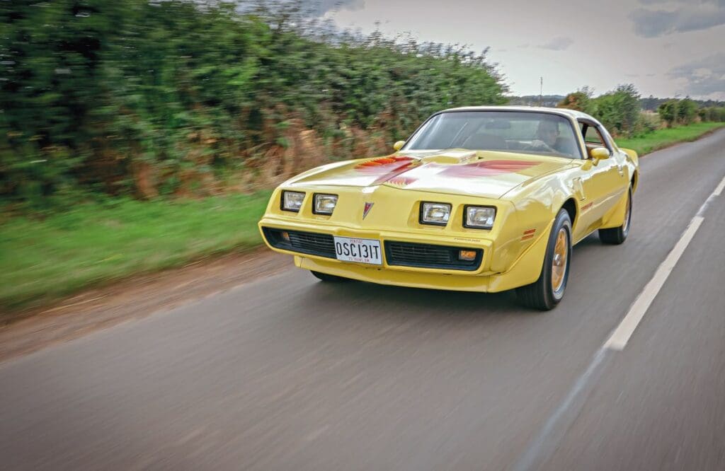 Front view of Pontiac Firebird Trans Am driving down road
