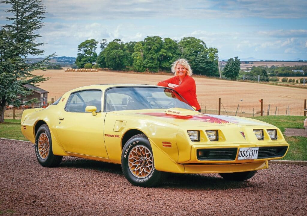 Jane leans against her yellow 1979 Pontiac Firebird Trans Am