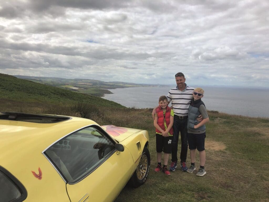 Grant with sons and the Firebid Trans Am on the coast overlooking Torness and Bass Rock.